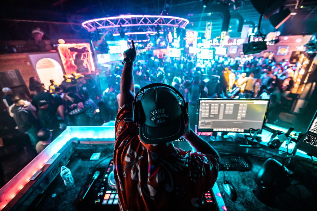 A DJ hyping up a nightclub crowd.
